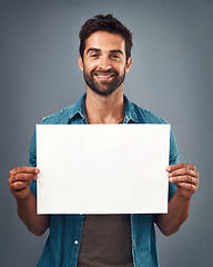 Image showing Happy man, portrait and billboard on mockup for marketing, advertising or branding against a grey studio background. Male person holding rectangle poster or placard for sign, message or advertisement