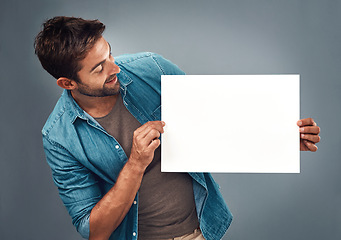 Image showing Man, billboard sign and mockup for marketing, advertising or branding against a grey studio background. Male person holding rectangle shape poster or placard for advertisement message with copy space