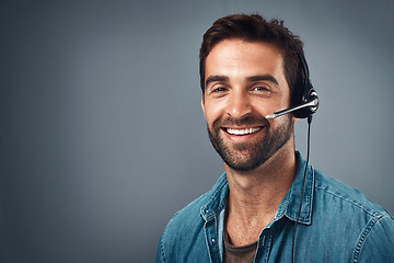 Image showing Happy man, call center and headphones on mockup space for consulting against a grey studio background. Portrait of friendly male consultant agent with smile and headset in contact us or online advice