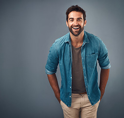 Image showing Portrait, mockup and man with a smile, fashion and confident guy against a grey studio background. Face, male person and model with happiness, casual outfit and laugh with clothes, relax and funny