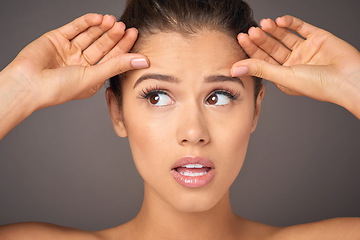 Image showing Stress, beauty and a woman with face wrinkles isolated on a dark background in a studio. Concern, worry and a young girl frustrated with skincare, filler and a facial botox cosmetics mistake