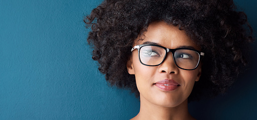 Image showing Optometry, vision and female model with glasses in studio with thinking, pensive or idea face expression. Optical wellness, healthcare and African woman with spectacles by blue background with mockup