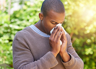 Image showing Blowing nose, hay fever and allergy with black man in park for spring, virus and sickness. Illness, spring and wellness with male person and tissue in nature for allergies, flu and congestion