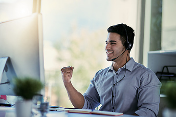 Image showing Callcenter agent, smile and winning, man with advice, celebration and happiness at help desk. Happy phone call, conversation and success, customer support consultant speaking into headset in office.