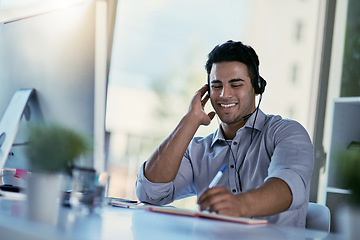 Image showing Customer support agent, smile and notes, man consulting with advice, sales information and help desk. Phone call, conversation and callcenter consultant writing in notebook while speaking in office.