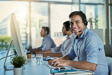 Image showing Customer service, coworking space and portrait of happy man consulting with advice and smile at help desk. Phone call, conversation and happiness, callcenter consultant typing at computer in office.