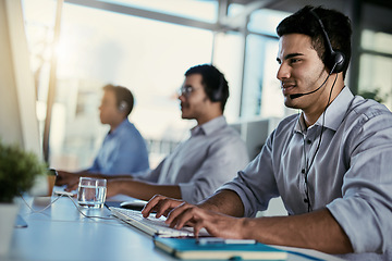 Image showing Crm agent, smile and man in coworking space consulting with advice and happiness at help desk. Happy phone call, conversation and customer support consultant speaking on headset in callcenter office.