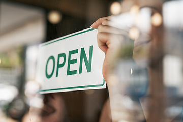 Image showing Open, sign and window with hands of person for coffee shop, restaurant and retail. Shopping, start and ready with closeup of employee and poster at door for cafe, small business and store