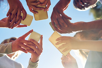 Image showing Hands, low angle and phone by friends together for social media, networking and sharing app on blue sky background. Below, smartphone and gen z people with internet, addiction or online communication