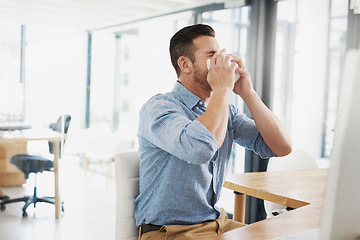 Image showing Business man, blowing nose and allergy in office with flu, virus and tissues for healthcare at desk. Young businessman, allergies or sick with hayfever, toilet paper and cleaning mucus in workplace