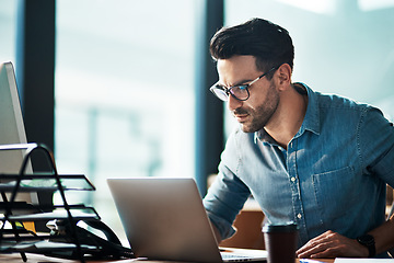 Image showing Serious, business man and laptop in office for planning, online research or developer reading data at desk. Focused worker, computer and website connection for digital project, internet or technology