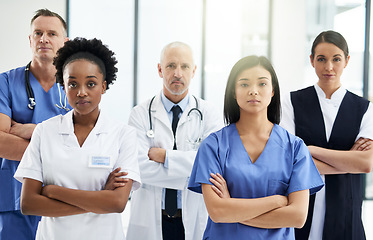 Image showing Healthcare, crossed arms and portrait of team of doctors standing in the hallway with confidence. Serious, diversity and group of medical workers in the corridor of a medicare clinic or hospital.