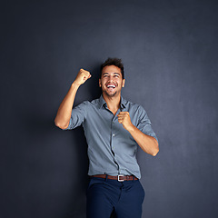 Image showing Portrait, happy man and winning fist in studio for success, victory or small business loan approval. Face, hand and male entrepreneur celebrating good news or career milestone on black background