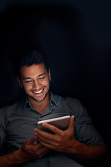 Image showing Business man, tablet and night with smile for meme, social media app or comic video on web, internet or blog. Young businessman, digital touchscreen and reading in dark workplace with funny article