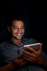 Image showing Happy business man, tablet and night with smile for meme, social media app or comic video on web, internet or blog. Young businessman, digital touchscreen or reading in dark workplace with funny chat