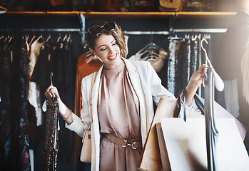 Image showing Stylist, rich or happy woman shopping in boutique store looking at clothes or choosing her favorite style. Choice, decision or female designer with trendy apparel picking an outfit or classy fashion