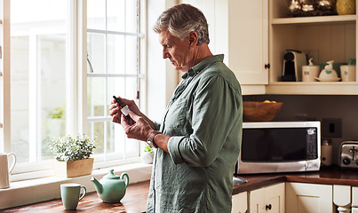 Image showing CBD oil, tea and a senior man in the kitchen of a retirement home for his morning medication routine. Thinking, medical cannabis and dose with a mature man holding a medicine bottle in his house