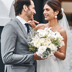 Image showing Flowers, wedding and love with a married couple standing outdoor together after a ceremony of tradition. Love, marriage or commitment with a man and woman outside looking happy as husband and wife