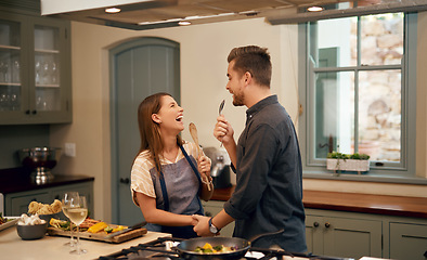 Image showing Love, home and couple in a kitchen, happiness and playful with joy, bonding and loving together. Partners, man and woman with affection, house or singing with humor, relationship or marriage with fun