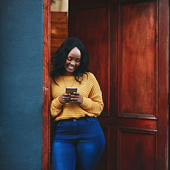 Image showing Phone, door and black woman in front of home with social media, smile and streaming or typing. Smartphone, property and female travel influencer with online review for accommodation or rental app