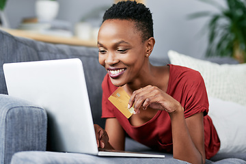 Image showing Laptop, credit card and black woman relax on a sofa for online shopping, e commerce and membership. Banking, credit score and female African person happy with payment, booking or customer experience