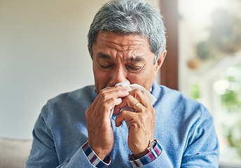 Image showing Senior man, sick and blowing nose in home from virus, allergy and illness on couch. Tired, tissue and elderly male person in a house lounge with sneeze from covid and flu on a sofa with allergies