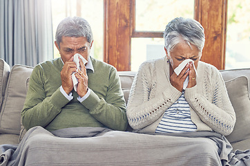 Image showing Senior couple, sick and blowing nose in home from virus, allergy and illness on living room couch. Tired, tissue and elderly people in a house lounge with sneeze from flu and cough on a sofa together