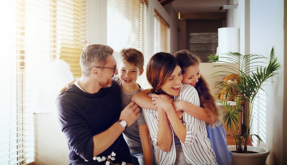 Image showing Happy, love and family in their new home, moving and loving with embrace, laughing and cheerful together. Parents, mother and father with kids, children and siblings in an apartment and milestone