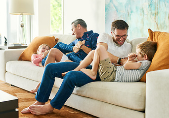 Image showing Gay parents, family fun and living room with dads and kids together with laugh and tickle. Parent love, bonding and care with father, papa and children in a home with a smile and lgbt people in house