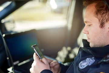 Image showing Police, officer and man texting with phone in patrol car for security contact, law enforcement update and mobile notification. Policeman typing message on cellphone for crime news, connection and app