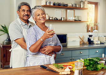 Image showing Portrait of old couple in kitchen with wine, hug and cooking healthy vegetable dinner together. Smile, happiness and food, senior man and happy woman with alcohol, vegetables and retirement wellness.