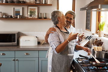 Image showing Cheers, wine and senior couple in kitchen cooking healthy food together on stove with smile, health and romance. Toast, drinks and old woman with man, glass and happiness, meal in pan and retirement.