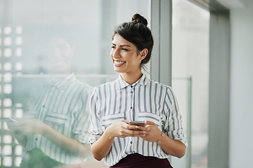 Image showing Business woman, thinking and phone with goal at office window with smile and idea. Female employee vision and mobile connection of a worker feeling happy on social media and technology at company