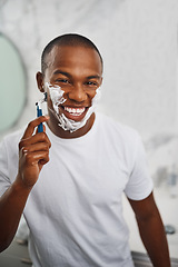 Image showing Black man, smile and shaving with blade, soap or grooming in mirror for self care in home bathroom. African guy, foam or cream for facial hair removal, razor or clean for hygiene in morning at house