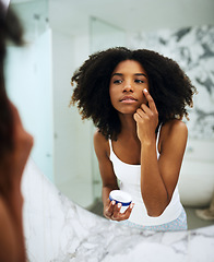 Image showing Skin care, bathroom mirror and black woman with lotion, cosmetic product and morning grooming. Health, wellness and dermatology, skincare at home and girl in reflection with cream on face for beauty.