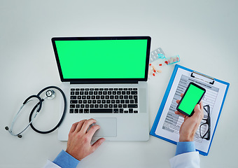 Image showing Phone, green screen and doctor hands with documents, healthcare service and planning research on laptop above. Space, telehealth and pills of medical person typing on mobile app mock up and computer