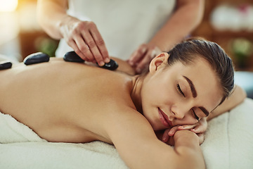 Image showing Spa, zen and woman getting a hot stone back massage for luxury, calm and natural self care. Beauty, body care and tranquil female person sleeping while doing a rock body therapy treatment at a salon.