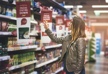 Image showing Shopping, woman at grocery store and in aisle searching and decision for product on a shelf. Customer or consumer, shopper for groceries and female person at supermarket or a shop looking for food