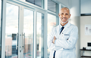 Image showing Mature doctor, leadership and portrait with arms crossed in hospital feeling proud from medical work. Healthcare, wellness and professional employee with happiness from health support and job