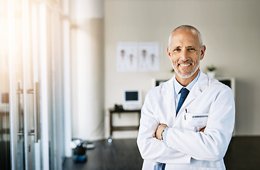 Image showing Mature doctor, smile and portrait with arms crossed in hospital feeling proud from medical work. Healthcare, wellness and professional employee with happiness from health support and physician job