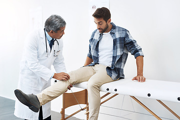 Image showing Clinic, patient and doctor with leg exam, consultation and wellness checkup of person at hospital. Medicine, health care expert and man in doctors office consulting medical professional for knee pain