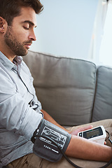 Image showing Hypertension, stress and man test blood pressure in a home sofa or living room for medical or health exam. Monitor, reading and man with equipment or machine for chronic disease in a house