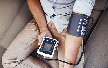 Image showing Hypertension, machine and man test blood pressure in a home sofa or living room for medical or health exam. Monitor, reading and person in a lounge equipment for chronic disease due to stress