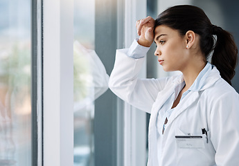 Image showing Thinking, stress and doctor by window in hospital with worry, anxiety and tired with headache in clinic. Healthcare, mental health and woman health worker with stressed out, depression and burnout