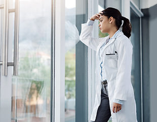 Image showing Stress, doctor and woman in hospital thinking with worry, anxiety and tired with headache in clinic. Healthcare, mental health and sad female health worker with stressed out, depression and burnout