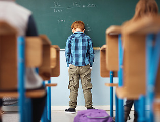 Image showing Rear view, boy student in detention with head on chalkboard and in classroom of school building. Anxiety or depressed for time out, math problems to solve and male kid with back to class.