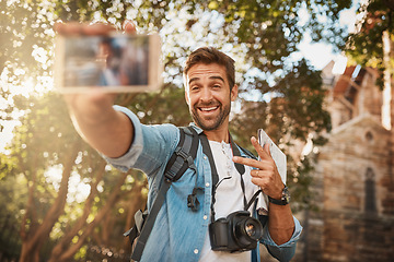 Image showing Happy man, tourist and peace sign selfie in a city for travel with holiday memory, smile and happiness. Male person outdoor on adventure, journey or vacation photo and freedom with a backpack