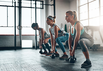 Image showing Kettlebell, fitness and women in a gym, training or workout goal with wellness, class or exercise. Female athlete, girls or squat with equipment, sports or relax with healthy lifestyle or challenge