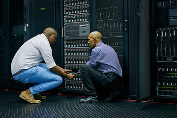 Image showing Server room, men or technicians talking about hardware together for a cybersecurity glitch with teamwork. IT support, collaboration or African engineers fixing network for information technology