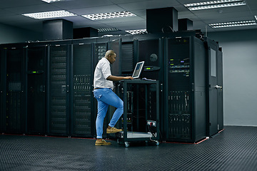 Image showing Server room, database and information technology with an engineer man at work on a network mainframe. Computer, programming and cybersecurity with a male technician working in IT support or safety